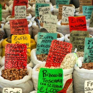 Vibrant assortment of beans and lentils in a Roman market, featuring colorful labels and diverse varieties.